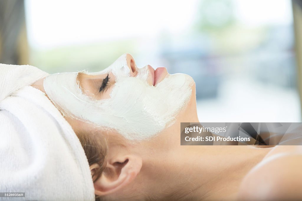 Ruhige Frau entspannen während einer Gesichtsbehandlung im ruhigen spa
