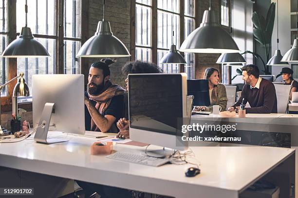 young creative business people working late in the office - small office stock pictures, royalty-free photos & images