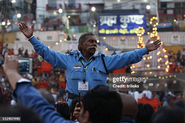 senior security guard standing with arms outstretched during ganga aarti - haridwar 個照片及圖片檔