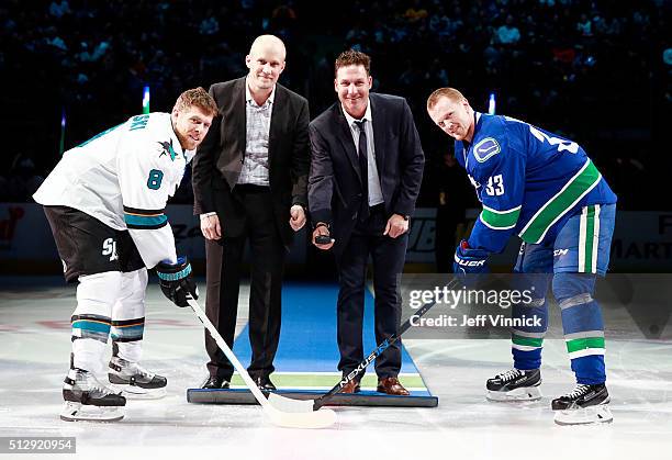 Henrik Sedin of the Vancouver Canucks and Joe Pavelski of the San Jose Sharks take the ceremonial face-off from former Canucks Sami Salo and Ed...