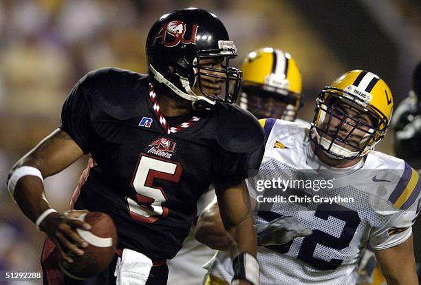 Devin Hollins of Arkansas State University looks to throw a pass under pressure from Ryan Willis of Louisiana State University on September 11, 2004...