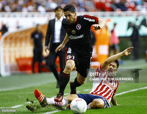 Michael Perez of Guadalajara vies for the ball with Gabriel Hauche of Tijuana during their Mexican Clausura 2016 tournament football match at...