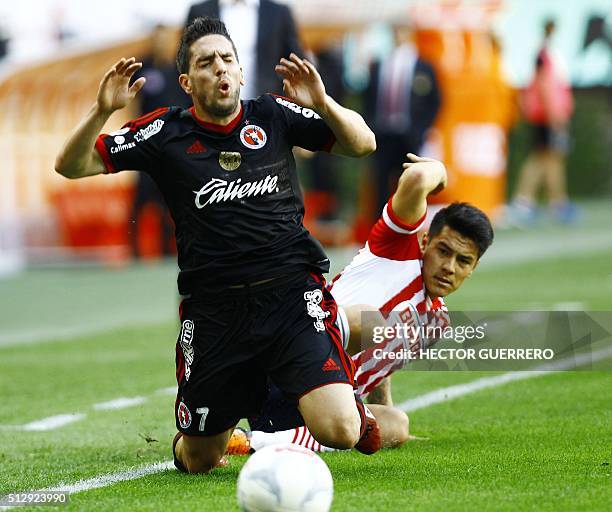 Michael Perez of Guadalajara vies for the ball with Gabriel Hauche of Tijuana during their Mexican Clausura 2016 tournament football match at the...