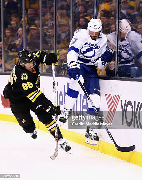 David Pastrnak of the Boston Bruins checks Alex Killorn of the Tampa Bay Lightning into the boards during the third period at TD Garden on February...