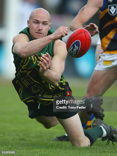 Ben Atkins of Tasmania fires off a handpass during the VFL Second Preliminary Final between Tasmania and Sandringham at Teac Oval, September 12, 2004...