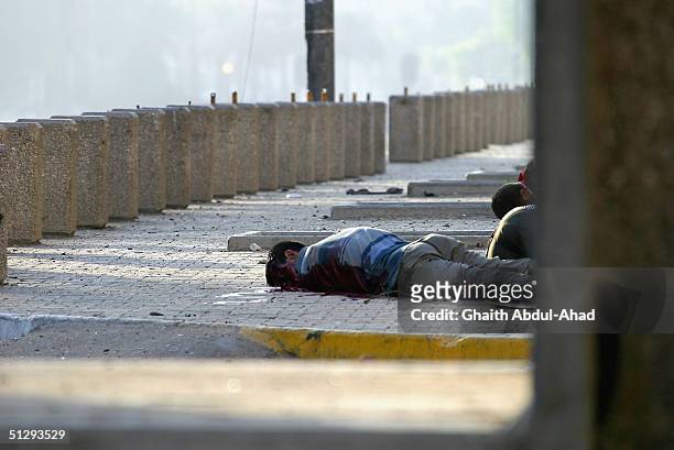 Dead Iraqi civilian is seen lying in the street on September 12, 2004 in Haifa Street, Baghdad, Iraq. Fighting broke out in the early hours of...