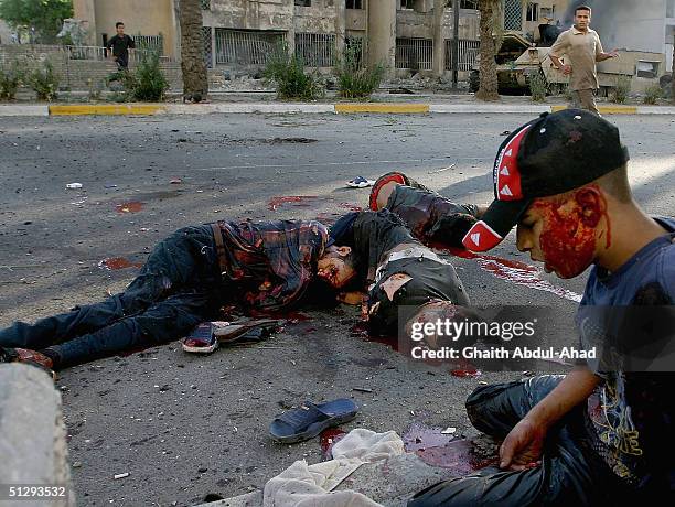 Dead and injured Iraqi civilians are seen lying in the street on September 12, 2004 in Haifa Street, Baghdad, Iraq. Fighting broke out in the early...