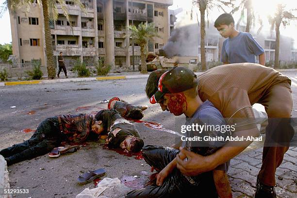 Dead and injured Iraqi civilians are seen lying in the street on September 12, 2004 in Haifa Street, Baghdad, Iraq. Fighting broke out in the early...