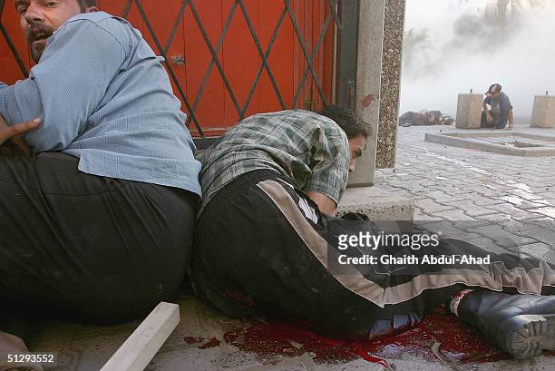 Injured Iraqi civilian take cover on September 12, 2004 in Haifa Street, Baghdad, Iraq. Fighting broke out in the early hours of September 12, 2004...