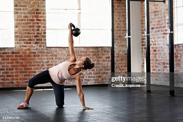 concentrating on building her strength - kettlebell stockfoto's en -beelden