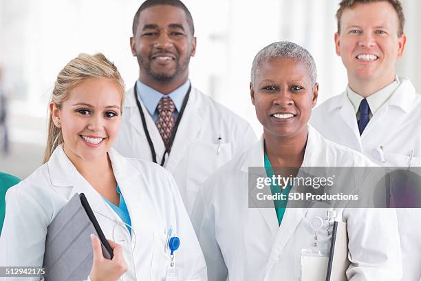 diverse group of hospital doctors and surgeons standing together - eye color stock pictures, royalty-free photos & images