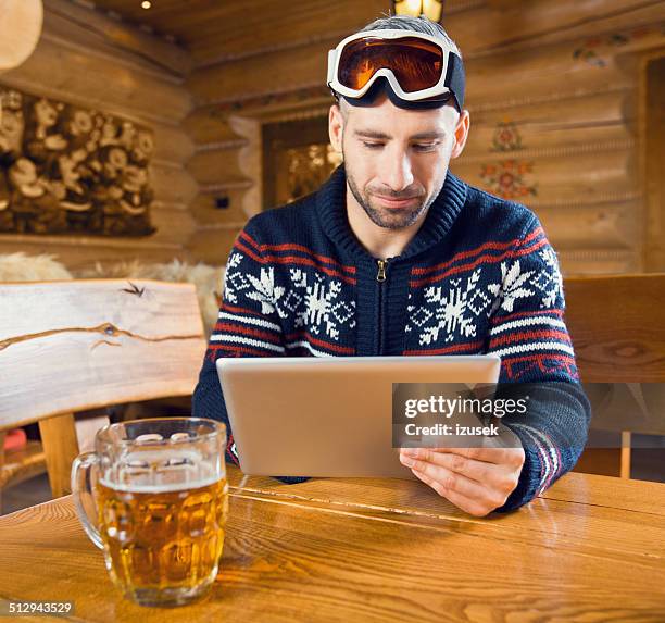 man using digital tablet - ski resort stock pictures, royalty-free photos & images