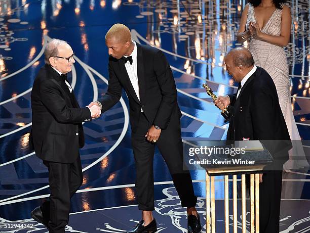 Composer Ennio Morricone accepts the Best Original Score award for ''The Hateful Eight' from musicians Pharrell Williams and Quincy Jones onstage...