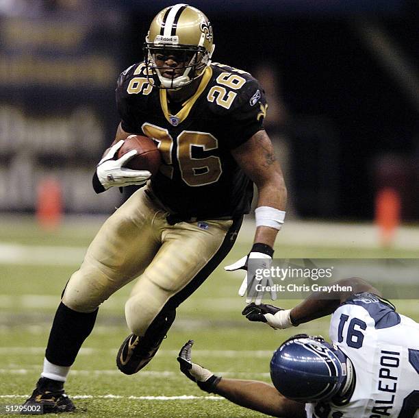 Deuce McAllister of the New Orleans Saints avoids a tackle by Anton Palepoi of the Seattle Seahawks September 12 at the Superdome in New Orleans,...