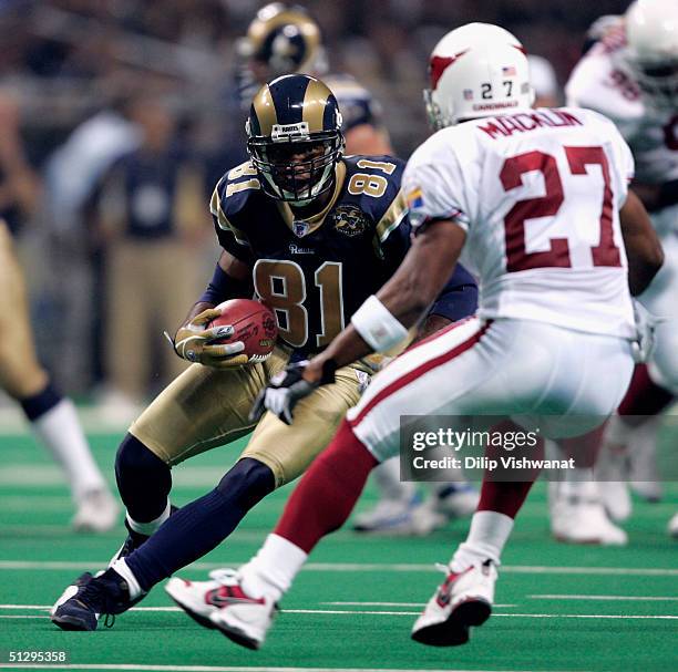 Torry Holt of the St. Louis Rams looks to avoid David Macklin of the Arizona Cardinals on September 12, 2004 at Edward Jones Dome in St. Louis,...