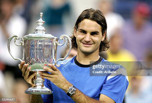 Roger Federer of Switzerland holds his trophy after winning the men's final over Lleyton Hewitt of Australia with a score of 6-0, 7-6, 6-0 in the...