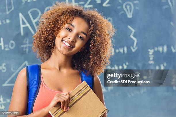 adorable teenage student standing in front of chalkboard in classroom - beautiful ethiopian girls stockfoto's en -beelden