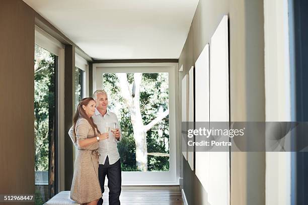 couple with champagne flutes looking at pictures - couple museum foto e immagini stock