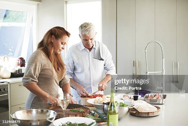 couple preparing food at kitchen counter - middle aged couple cooking ストックフォトと画像