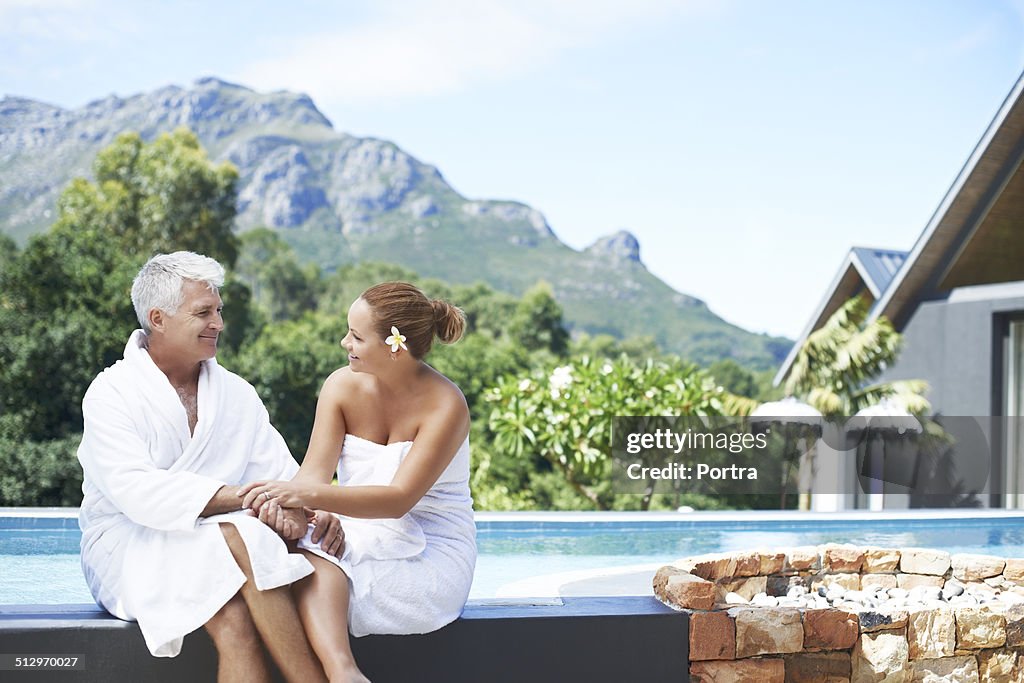 Couple sitting on the edge of swimming pool