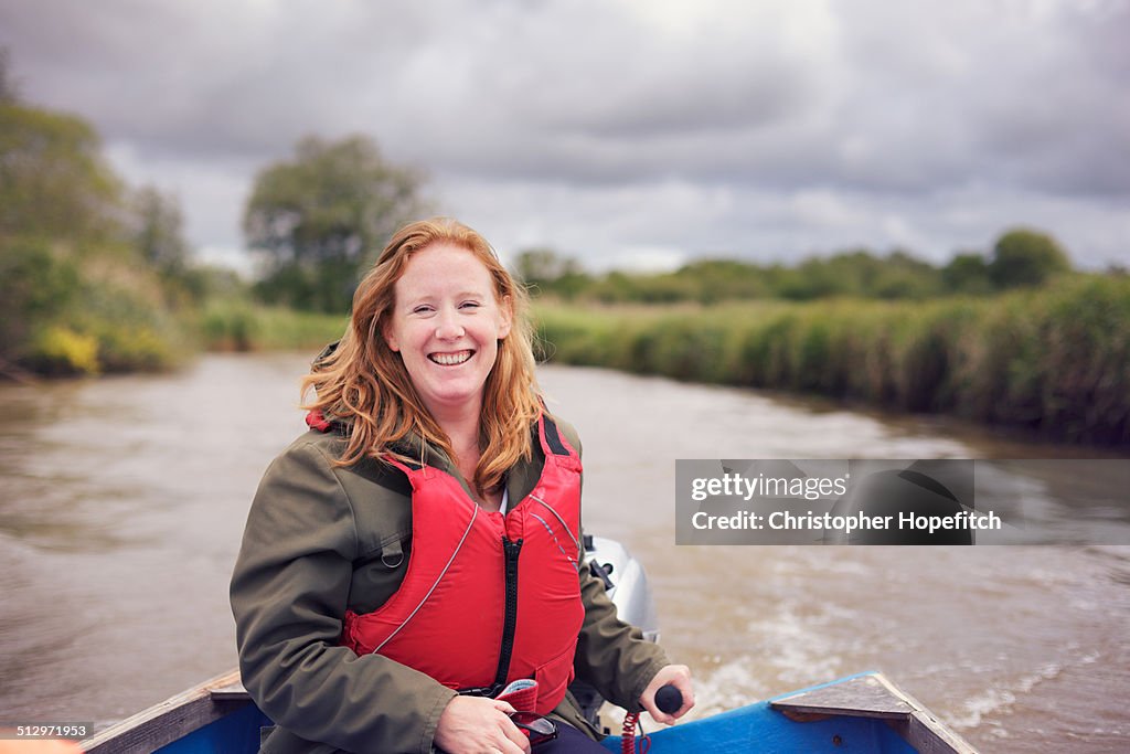 Happy woman piloting small boat