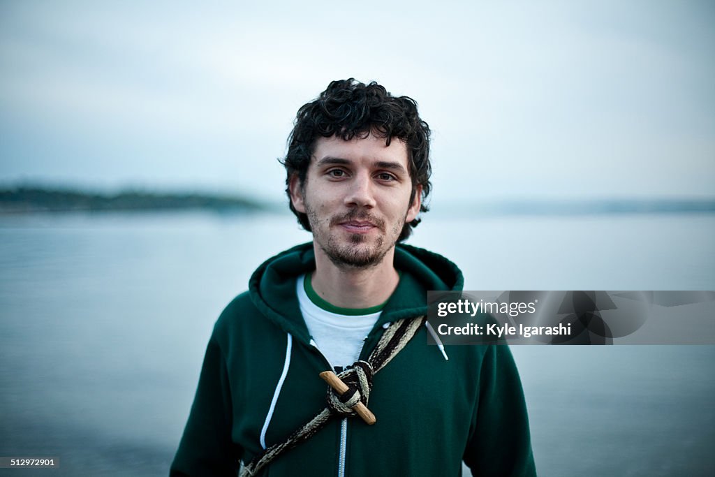 Young man in hoodie by the water