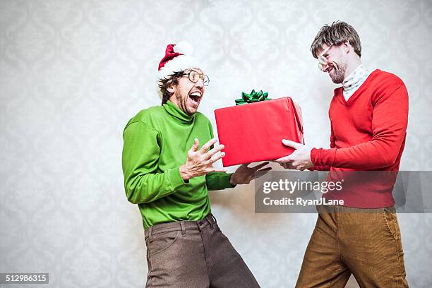 christmas nerd giving present - tacky christmas sweater stock pictures, royalty-free photos & images