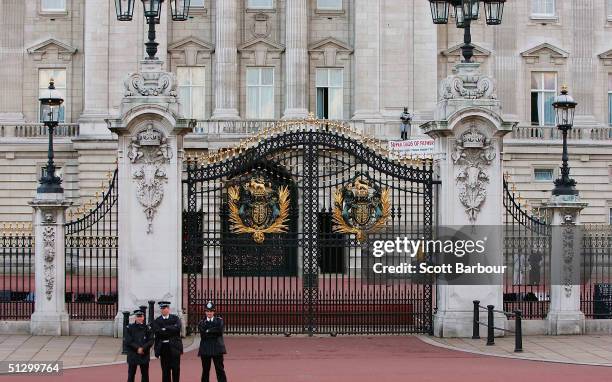 Jason Hatch, a Fathers 4 Justice campaigner dressed as Batman protests on the balcony at Buckingham Palace as British police officers look on on...