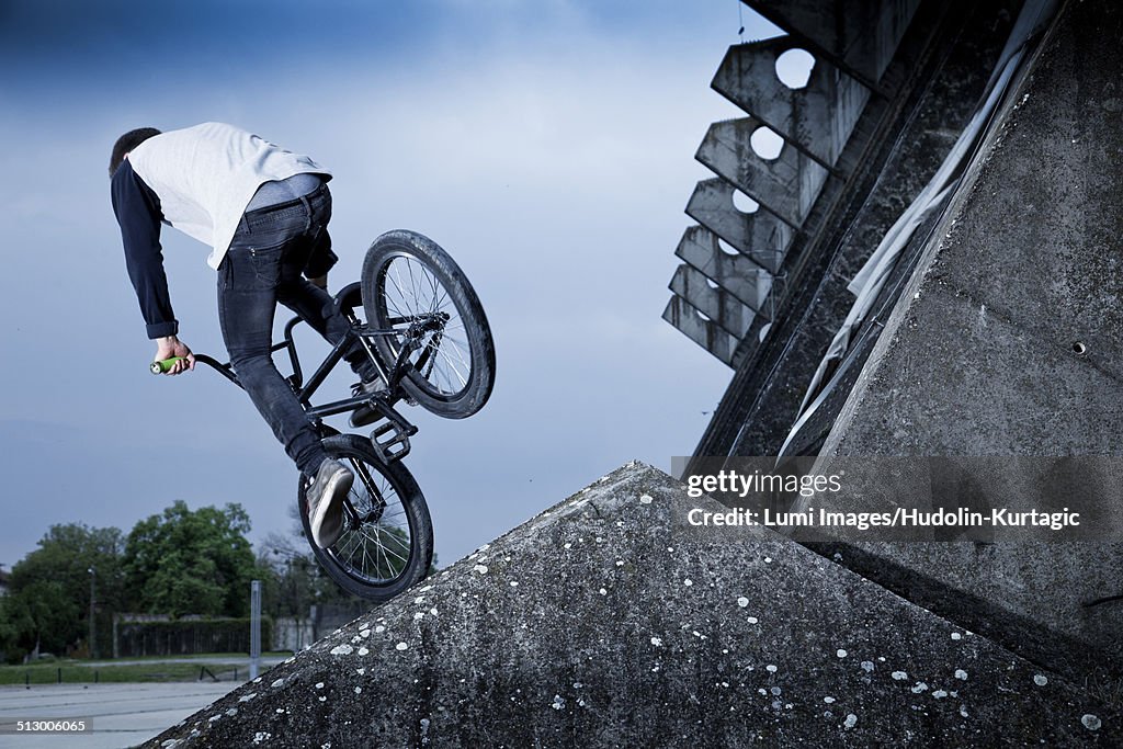 BMX biker performing a stunt on a bridge