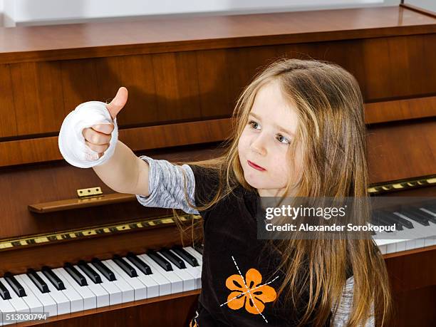 the little optimistic pianist despite the broken hand - elastic bandage fotografías e imágenes de stock