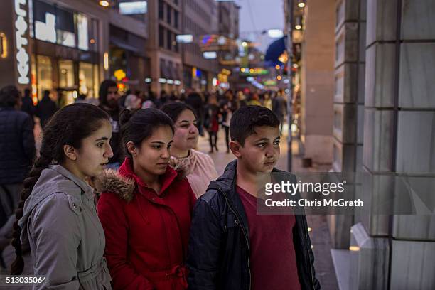 Syrian refugees, sisters, Reem, Ronak, Zahra and brother Ronnie look at an art gallery on Istiklal street on February 28, 2016 in Istanbul, Turkey....