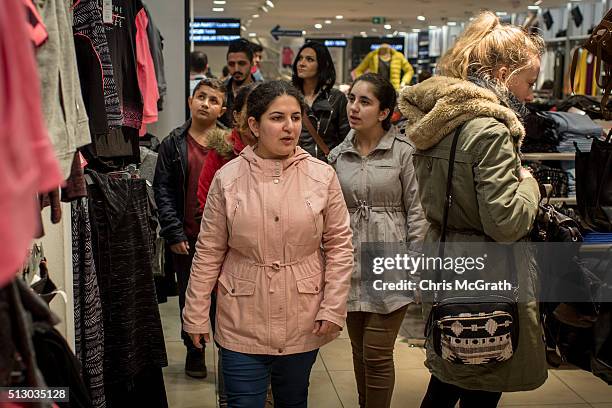 Syrian refugee sisters, Zahra, Reem, Ronak and brother Ronnie walk through an outlet store on February 28, 2016 in Istanbul, Turkey. Turkey is...