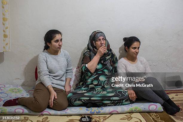 Syrian refugee's, Reem and Ronak watch tv with their mother Fatima on their day off from work on February 28, 2016 in Istanbul, Turkey. Turkey is...