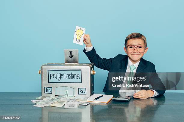 business boy puts ideas in machine and makes danish money - danish money stock pictures, royalty-free photos & images