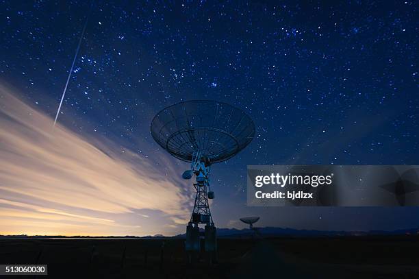 antena parabólica bajo un cielo estrellado cielo - satellite space fotografías e imágenes de stock