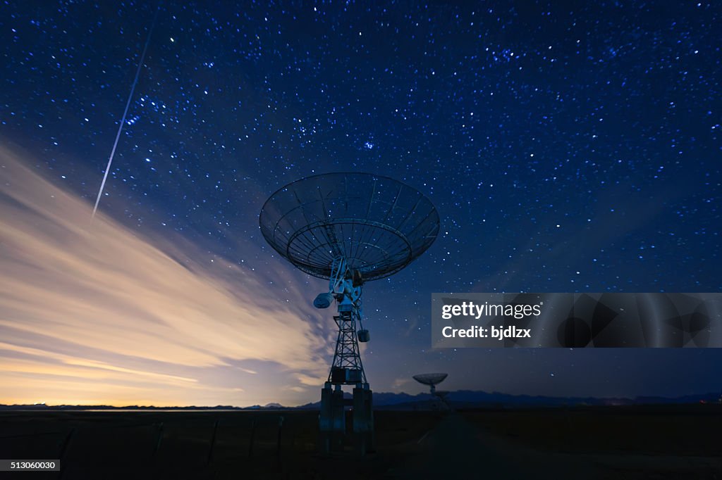 Antena parabólica sob um céu estrelado