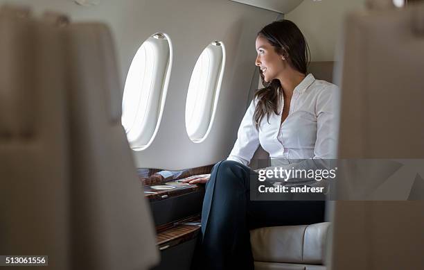 successful woman in a business trip - first class plane stockfoto's en -beelden