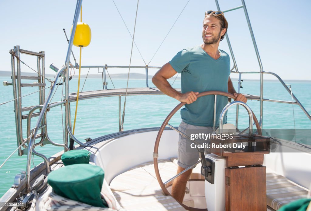 Mann steuert Segelboot auf dem Wasser