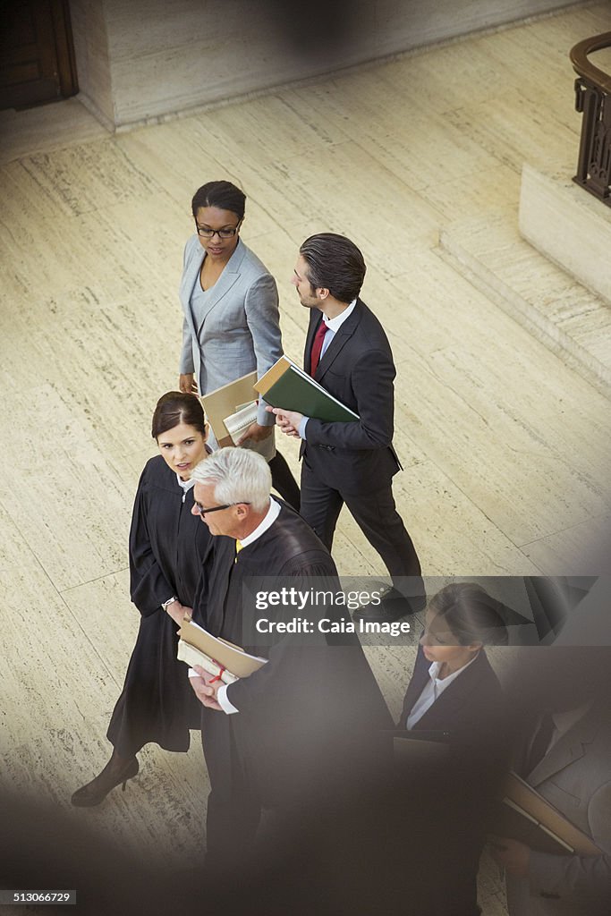 Judges and lawyers walking together in courthouse