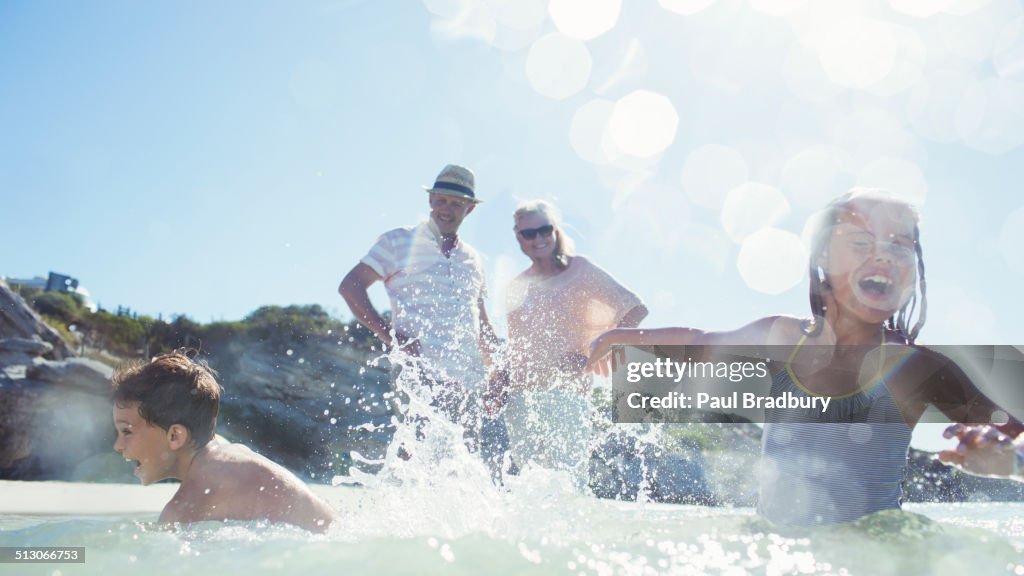 Family splashing each other on beach