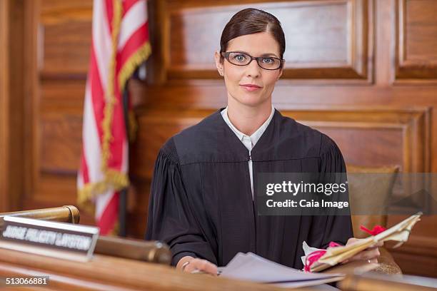 judge examining documents at judges bench in court - judge robe stock pictures, royalty-free photos & images