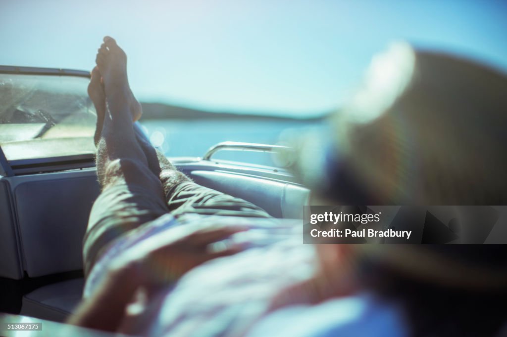 Hombre relajándose en barco cerca de la playa