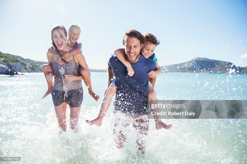 Family running in water on beach