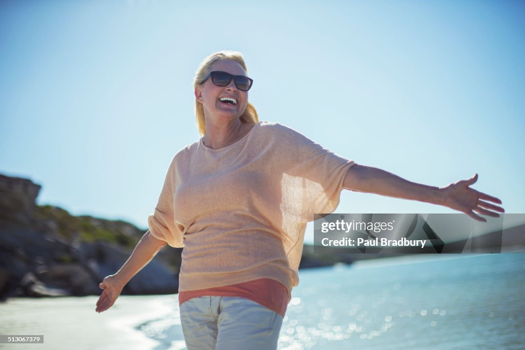 Femme âgée souriant au soleil sur la plage