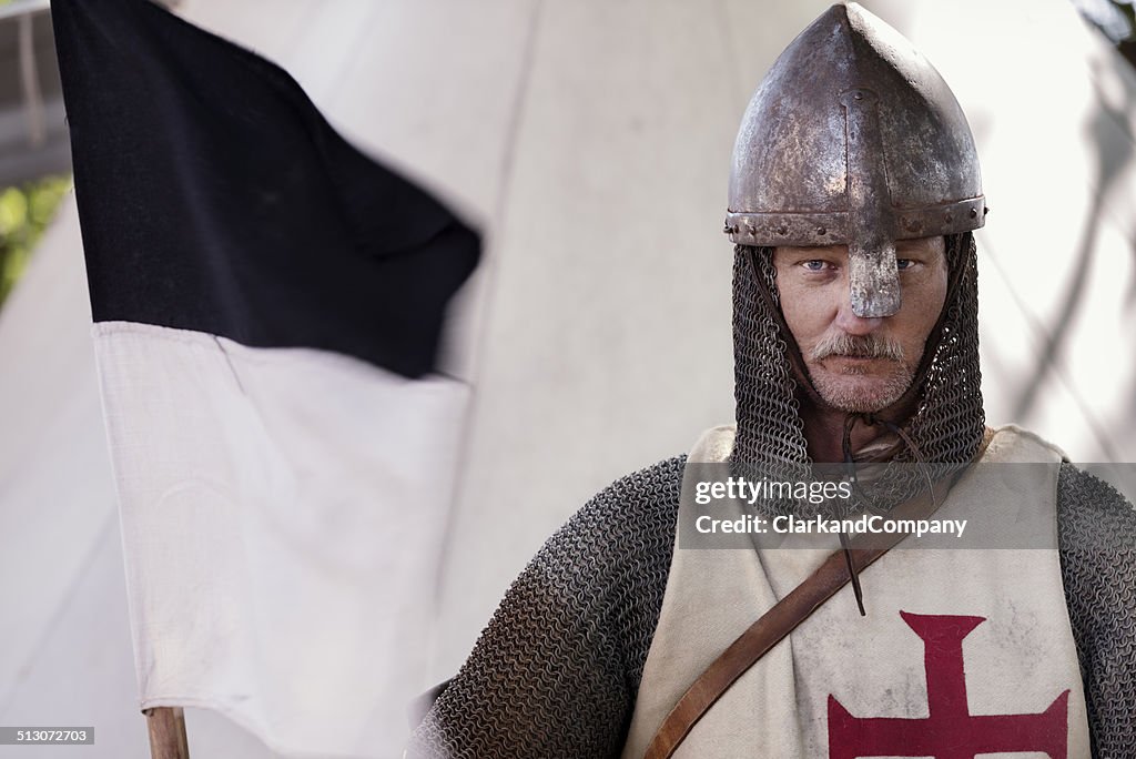 Popa mirando hacia Knight sostiene una bandera Regimental.
