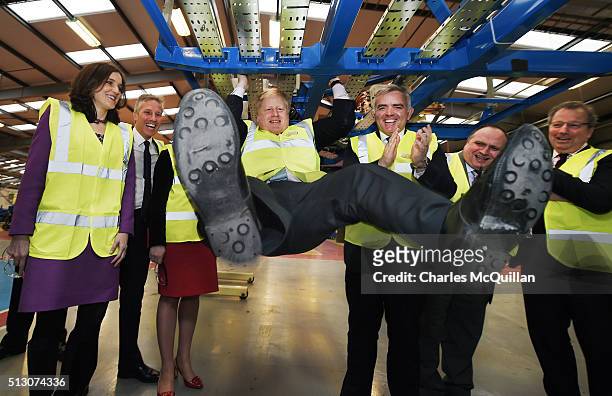 Mayor of London Boris Johnson attempts a pull up while inspecting one of the ordered London buses at Wrightbus' Antrim factory watched by among...