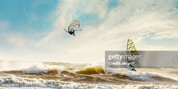 windsurfers enjoying a stormy day in the netherlands - windsurf stockfoto's en -beelden