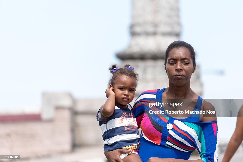 Afro Caribbean young single mother carrying her young...