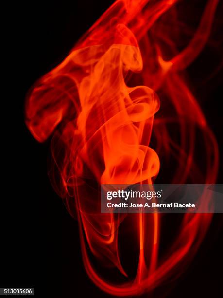 stelas and figures of orange smoke on a  black blackground. - black blackground stock pictures, royalty-free photos & images