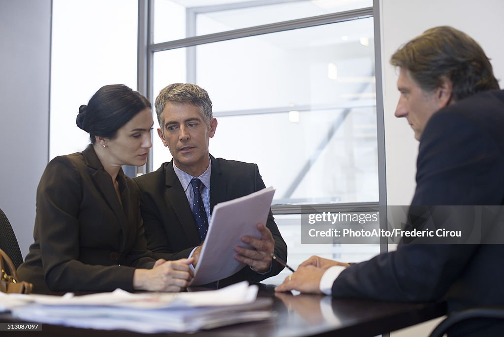 Business meeting, business associates reviewing contract